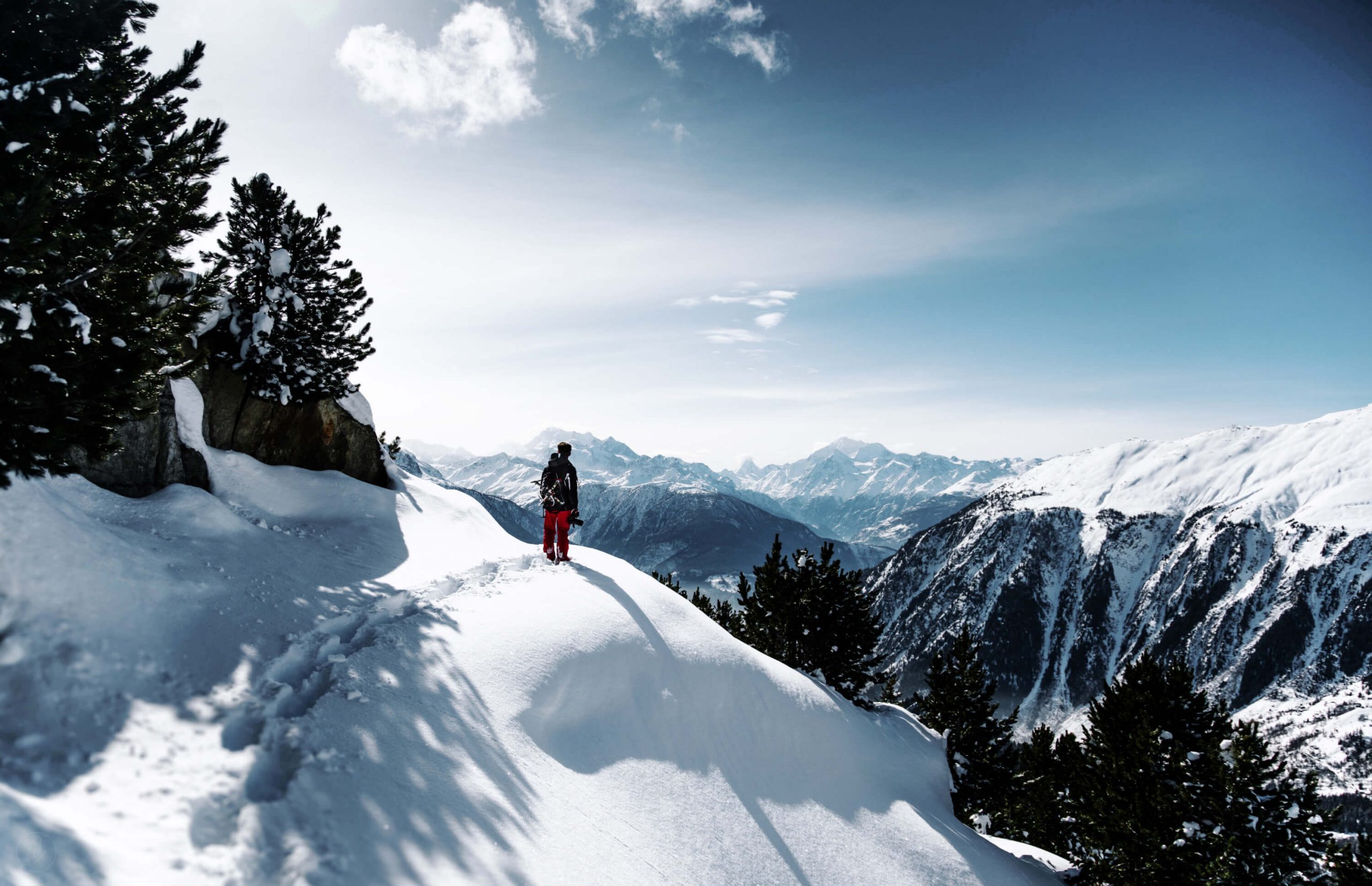 Person står i vinterlandskap och blickar ut över bergen